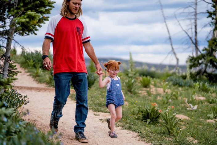 dad walking with young daughter on a hiking trail