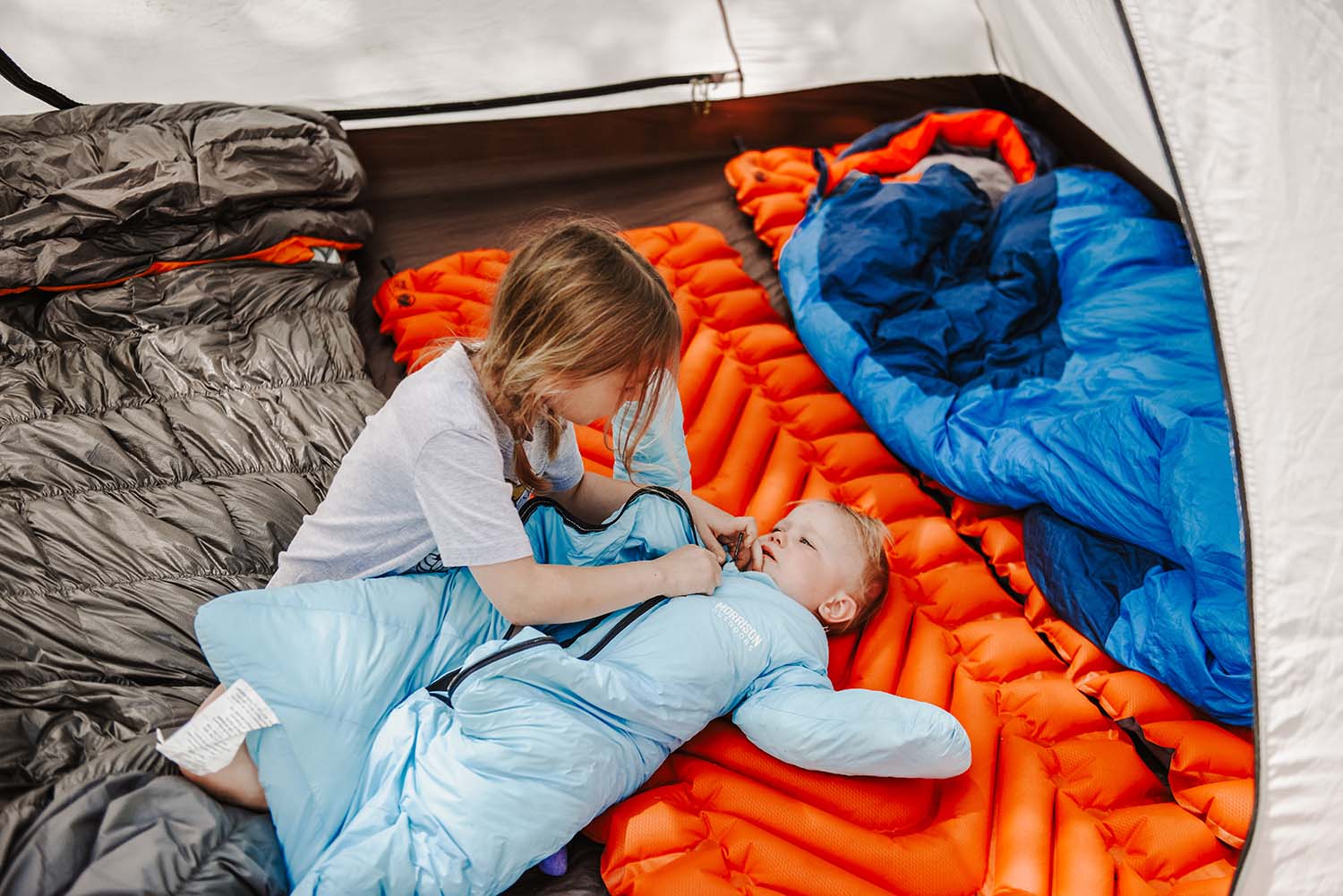 baby and young child in tent wtih sleeping bags