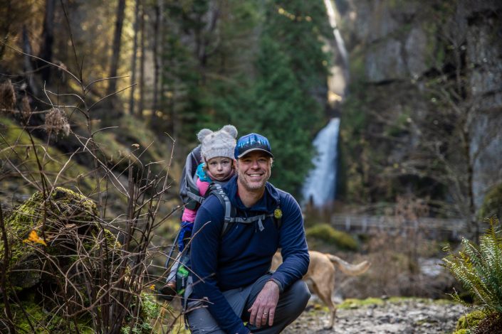 man with child in a frame child carrier hiking