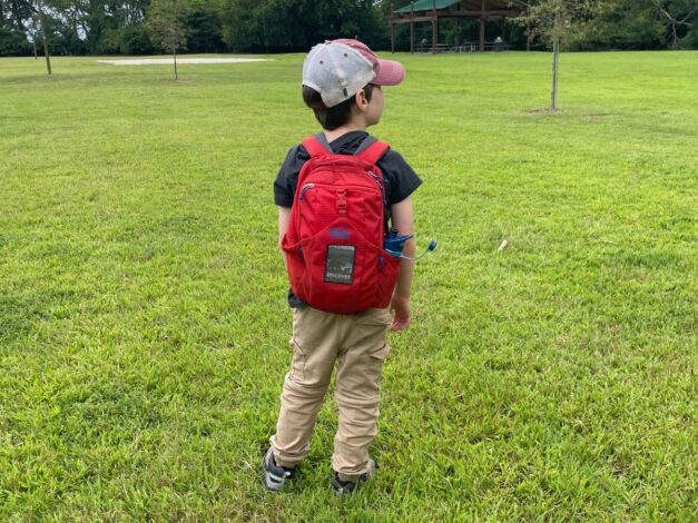 Child outdoors wearing backpack
