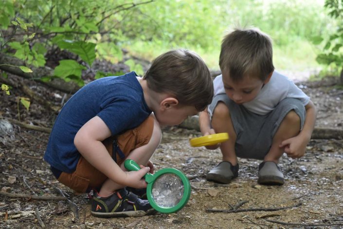 boys looking at nature with magnifying lenses