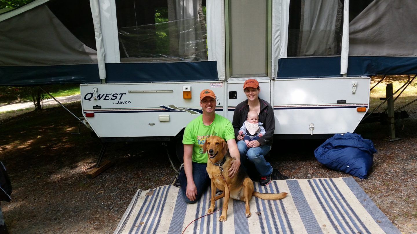 Family sitting outside their camper