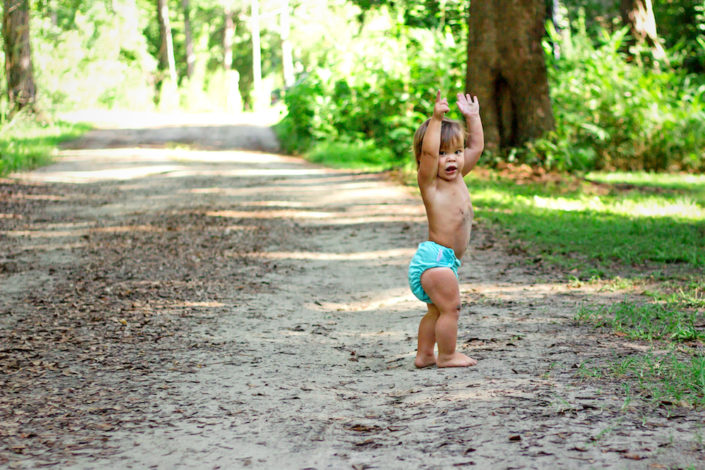 Cloth Diapering while Hiking by Andrea Zimmer for Hike it Baby (photo by Lauren Adams: image o a child wearing a blue cloth diaper walking barefoot down a trail)