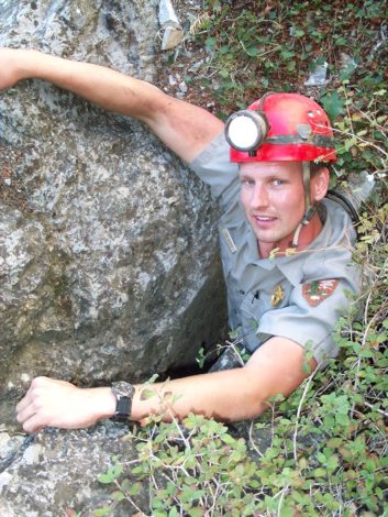 Recreation Specialist Interview with Jon Jasper by Maggie Fram for Hike it Baby: Jon Jasper emerges from a cave opening.