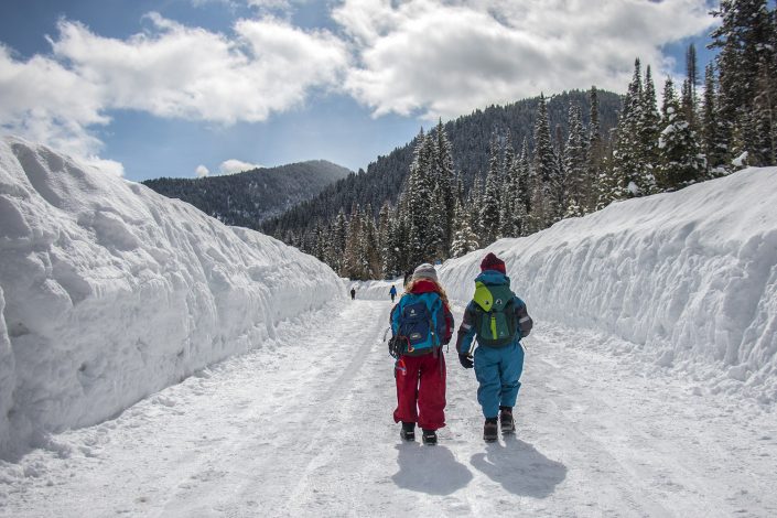 two kids hiking on a snowy trail