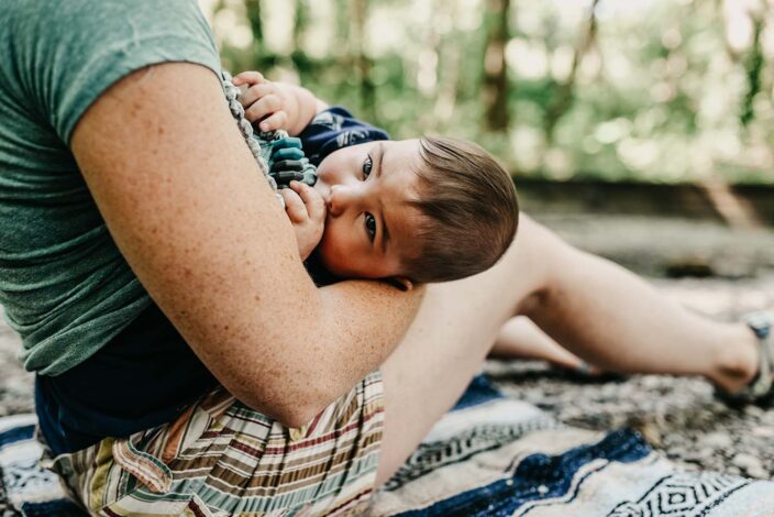 woman breastfeeding baby while outside