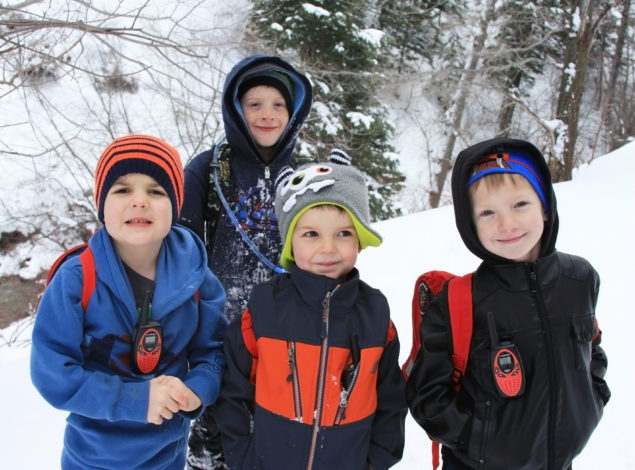 4 boys on a winter trail with hiking backpacks