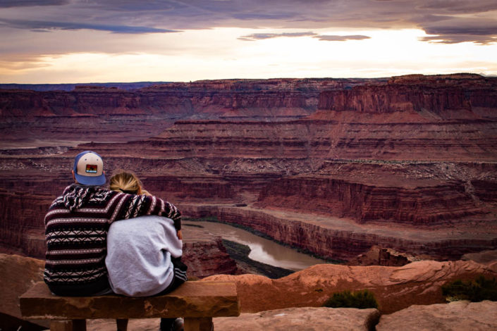 Couple on a bench in Moab desert overlooking a canyon