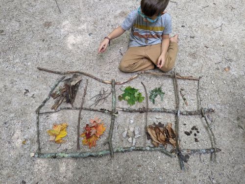 Child using nature for math activity.